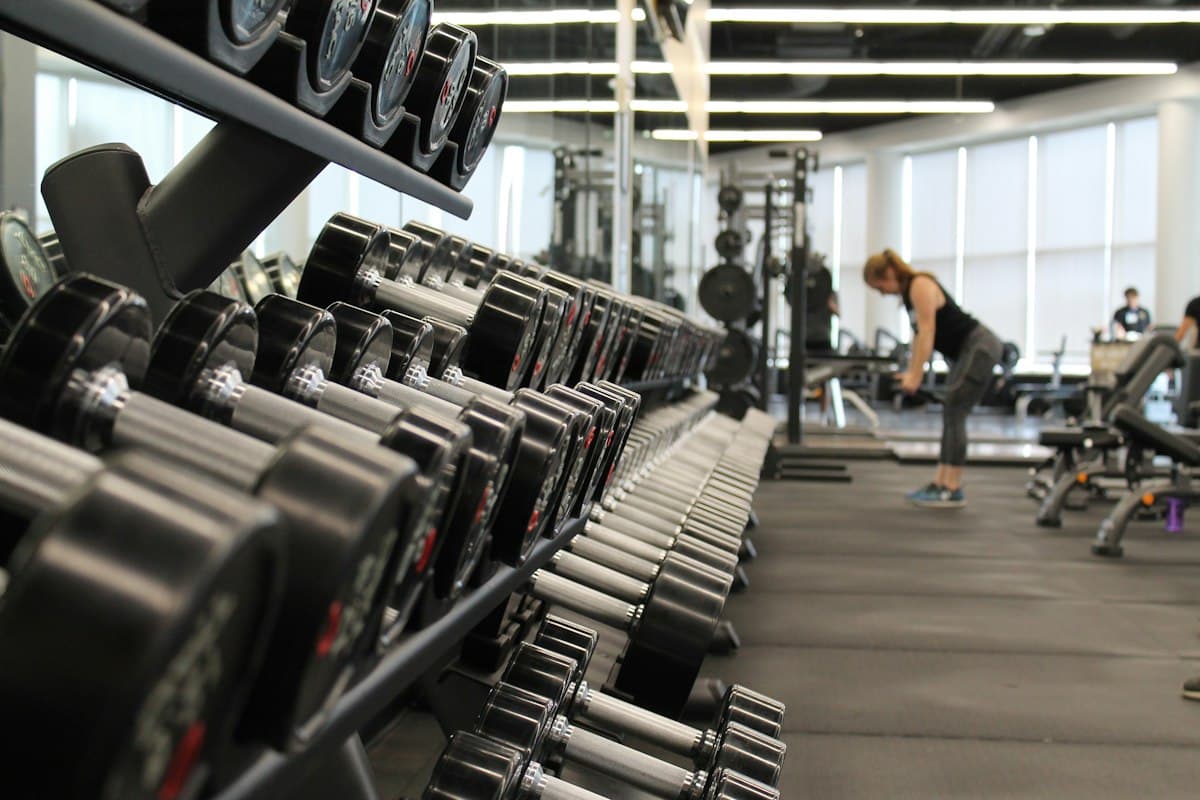 A rack of dumbbells in a bright, quiet gym